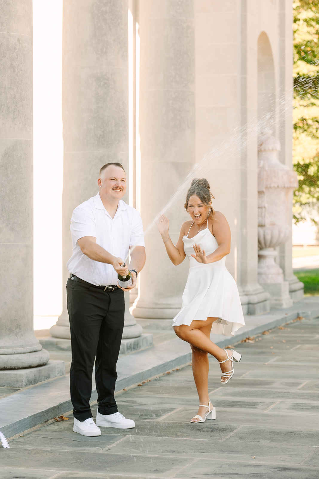 Gabrielle & Derrick popping champagne at their Neumors estate engagement session