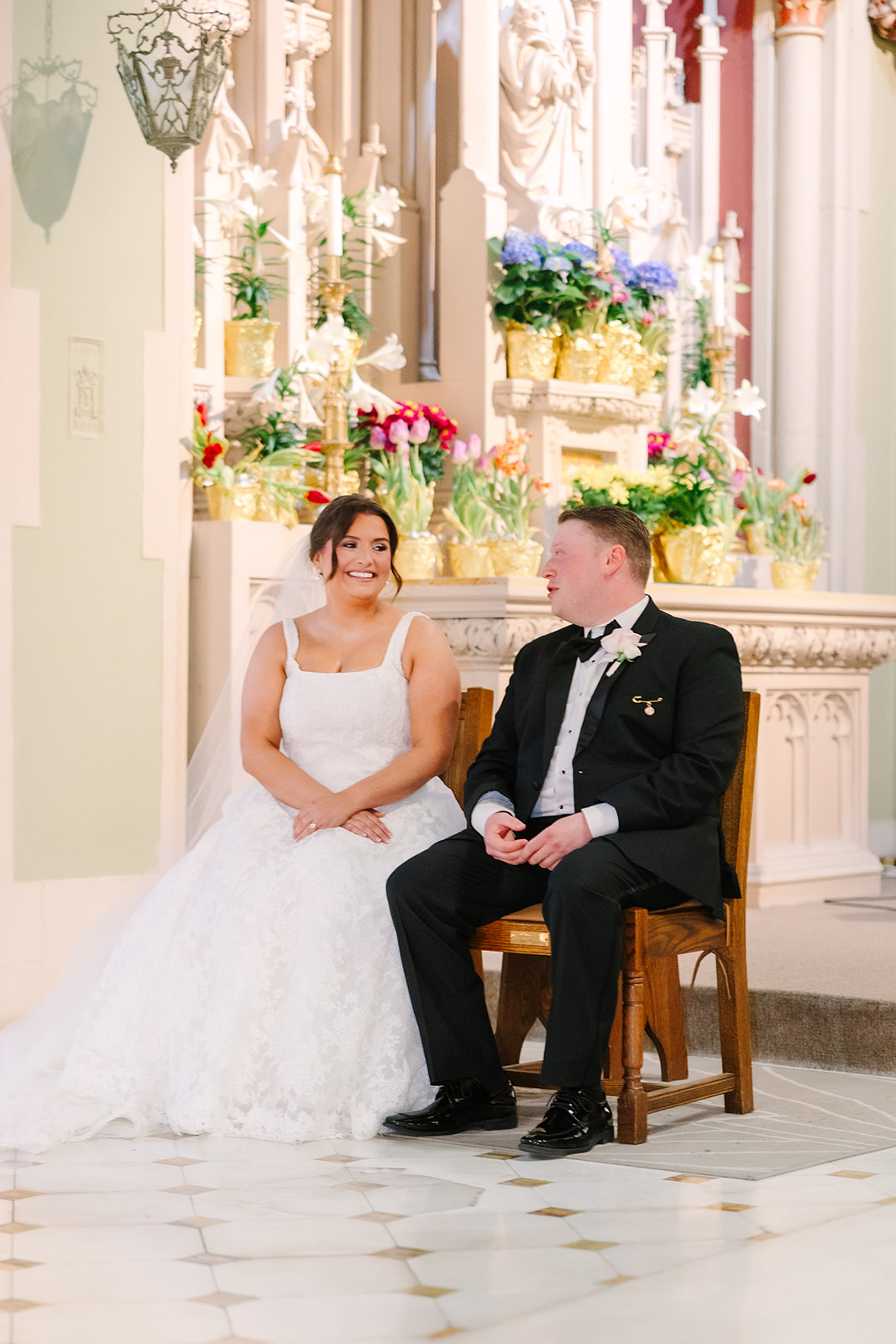 Ashley and Trevor sitting together during their philadelphia church wedding ceremony